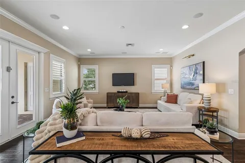 a kitchen with stainless steel appliances kitchen island granite countertop a stove a sink a refrigerator a microwave oven with white cabinets and wooden floor