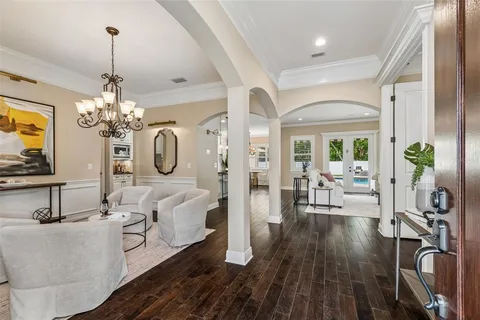 a living room with couches a table and a chandelier