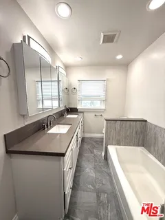 a large kitchen with kitchen island a sink stainless steel appliances and a counter top space