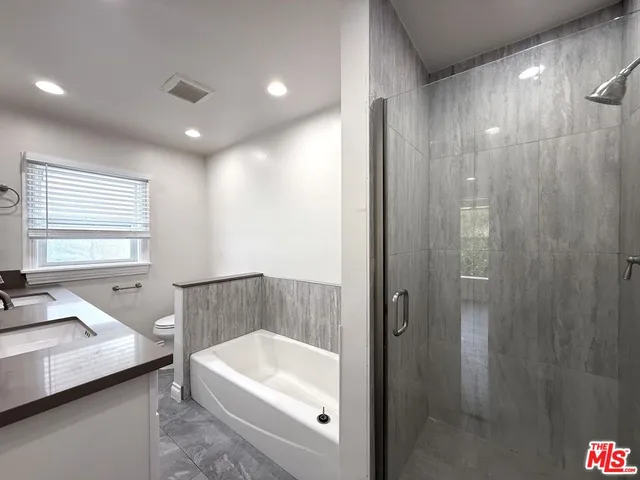 a bathroom with a tub a sink and a shower