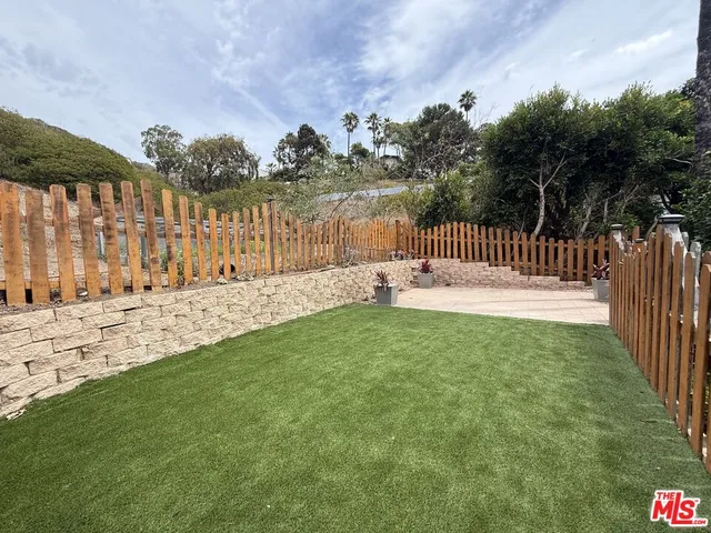 a view of a yard with wooden fence
