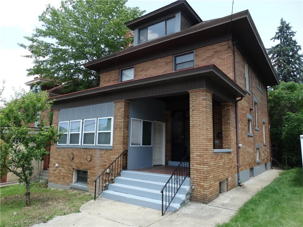 a front view of a house with a tree