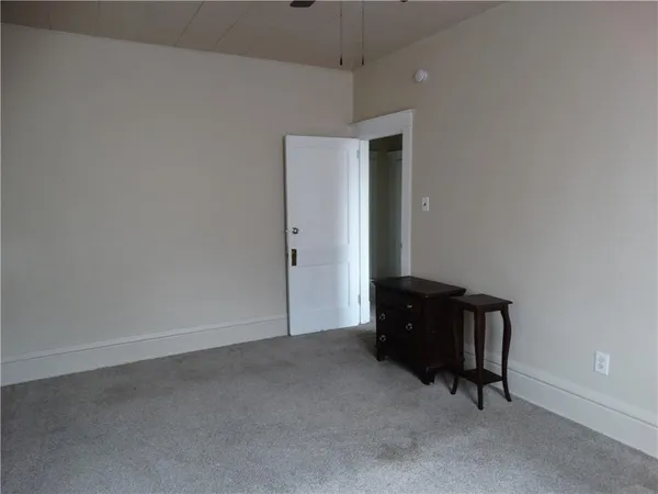 an empty room with closet and windows
