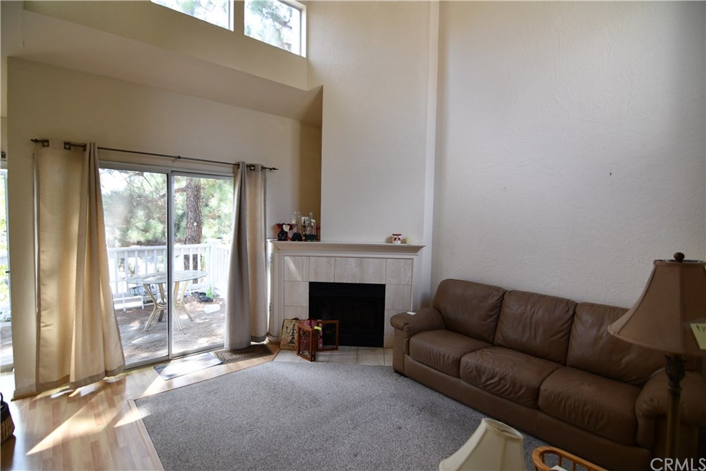 Living room features high cathedral ceilings and a fireplace. Slider out to your
private deck area.