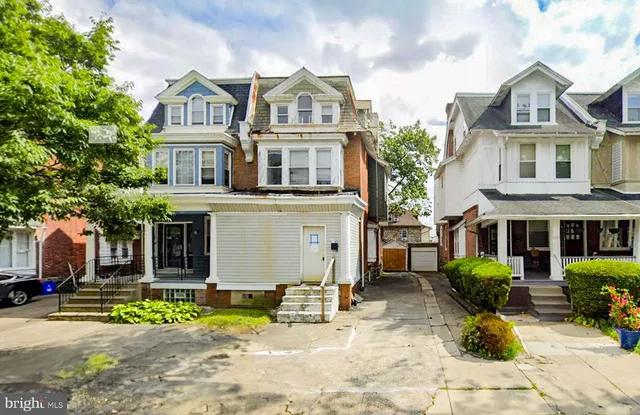 a view of a white house with large windows and a table and chairs