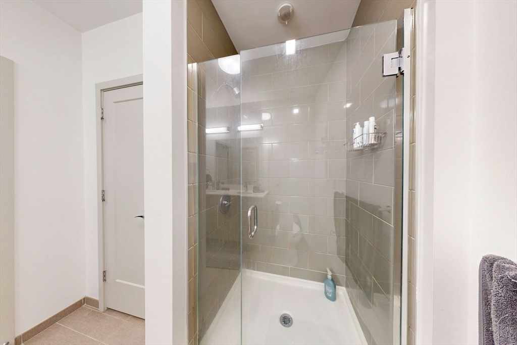 180 Telford Street, Unit 321 Boston, MA 02135 - Photo 10 of 16 a bathroom with a glass shower door