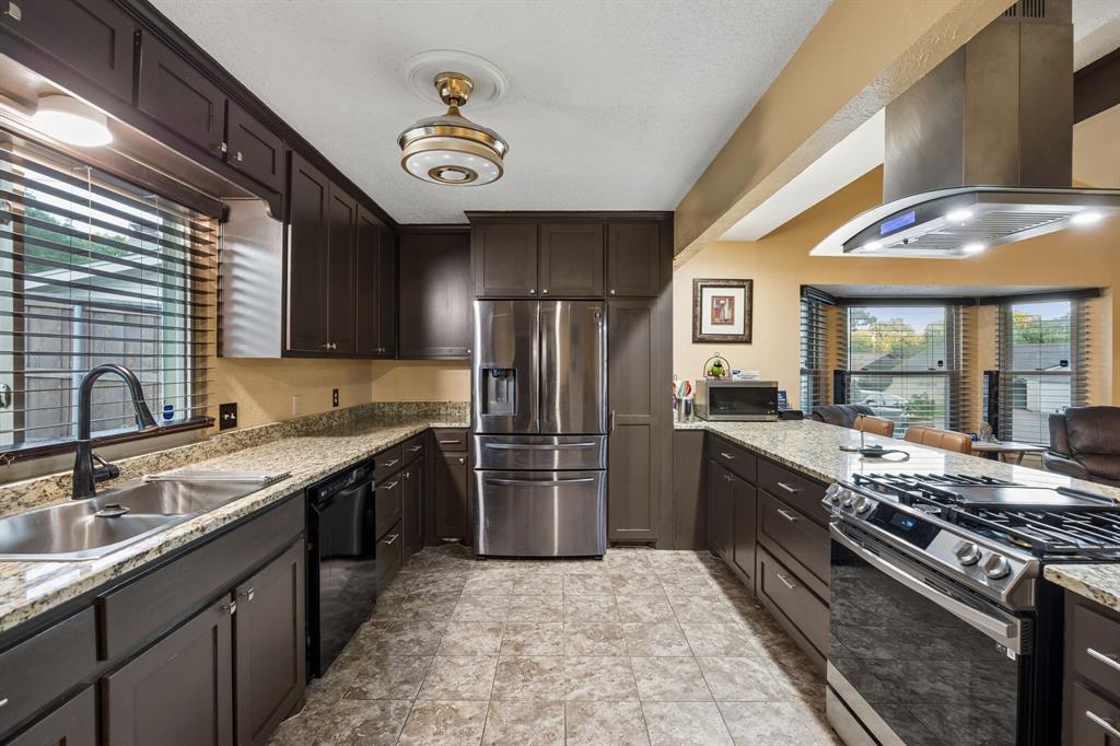 2617 Quail Ridge Irving, TX 75060 - Photo 12 of 17 Galley kitchen featuring dark wood cabinetry and stone-finish countertops
