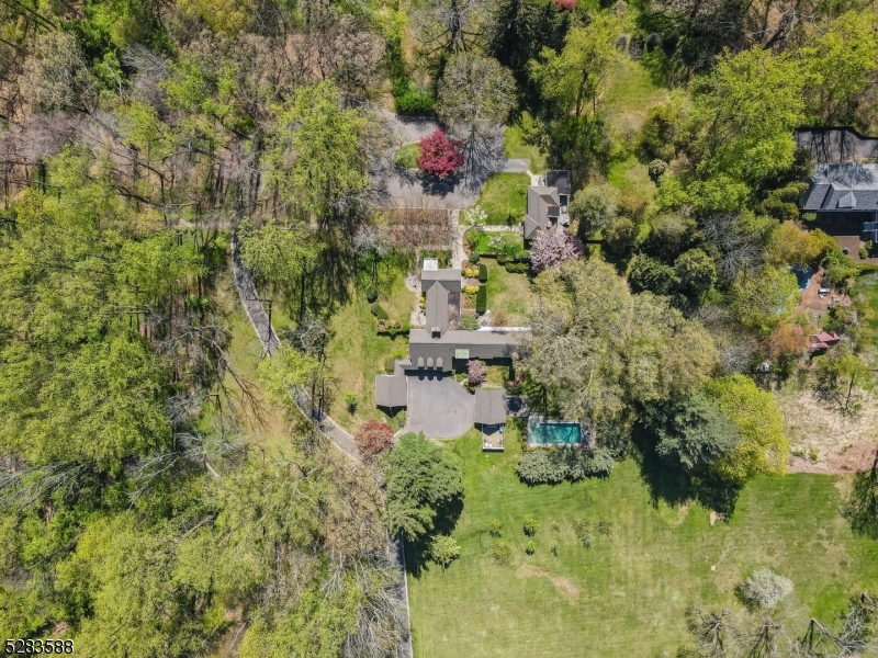 a aerial view of residential house with outdoor space and trees around
