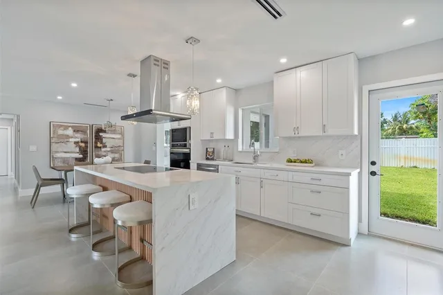 a kitchen with white cabinets and chairs