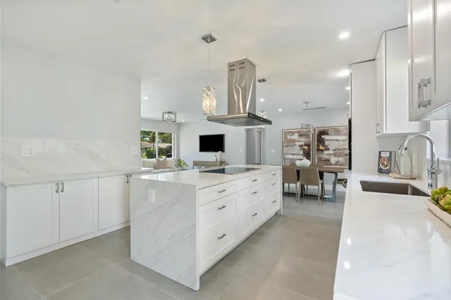 a large white kitchen with cabinets