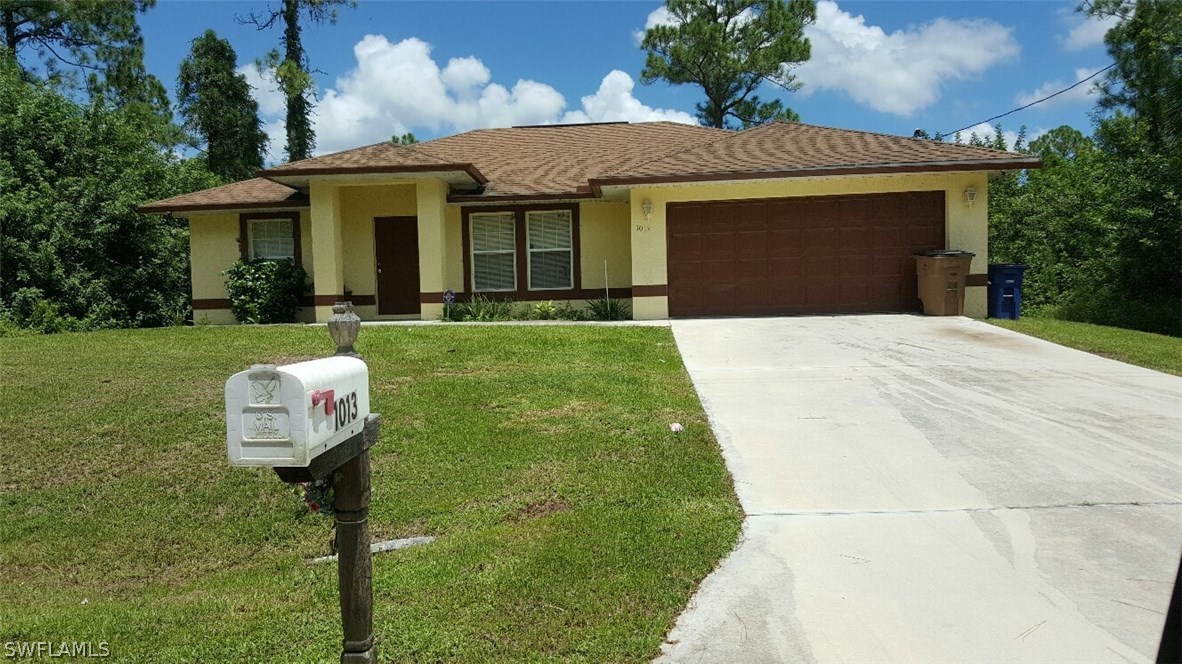 a front view of a house with a yard and garage