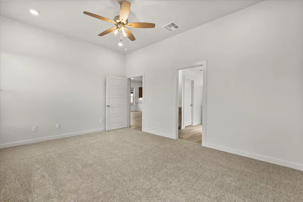 an empty room with closet and a ceiling fan