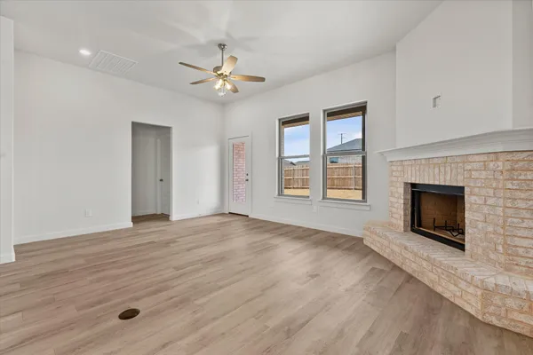 a view of empty room with fireplace and fan