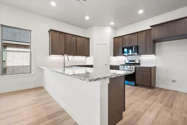 a kitchen with stainless steel appliances granite countertop a sink stove and refrigerator