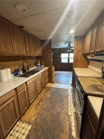 a kitchen with granite countertop a sink a stove and cabinets