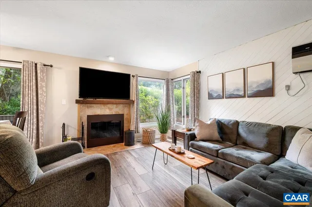 a living room with furniture a flat screen tv and a fireplace