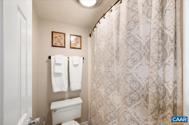 a bathroom with a toilet and a shower curtain