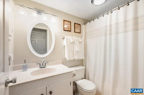 a bathroom with a toilet a sink and a mirror