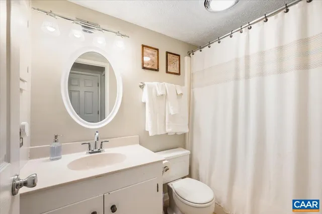 a bathroom with a toilet a sink and a mirror