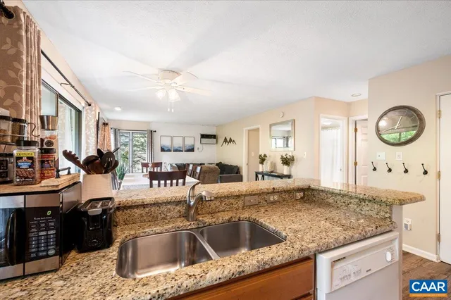 a kitchen with granite countertop a sink a stove and a wooden floor