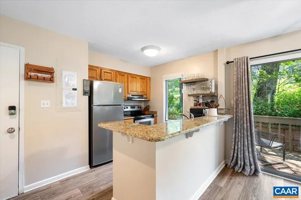 a kitchen with refrigerator a counter space and wooden floor