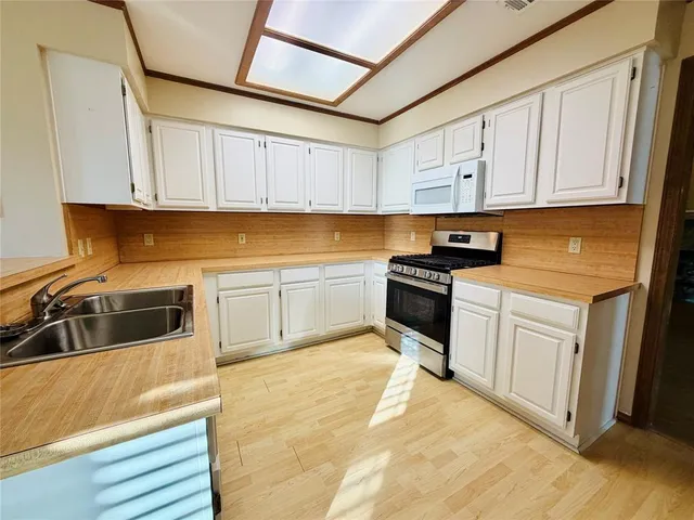 a kitchen with granite countertop white cabinets and white appliances