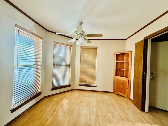 an empty room with wooden door and windows
