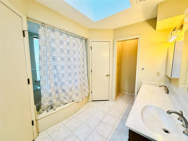 a bathroom with a tub shower and sink