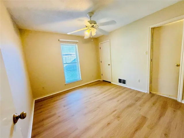 a view of a room with wooden floor and a ceiling fan