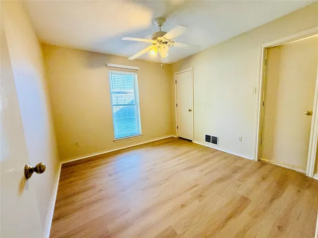 a view of a room with wooden floor and a ceiling fan