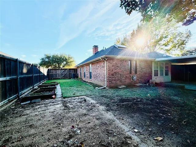 a view of a backyard with potted plants and a large tree