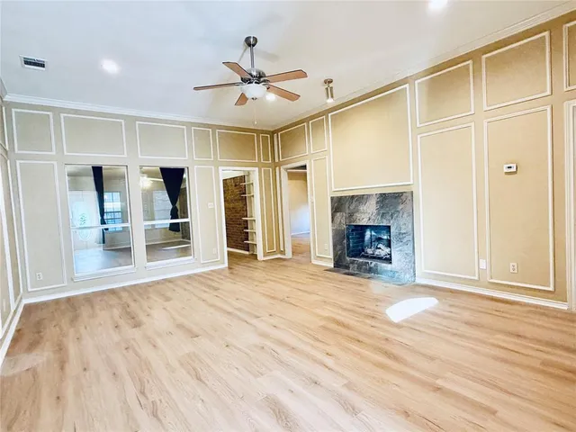 a view of an empty room with a fireplace and a window