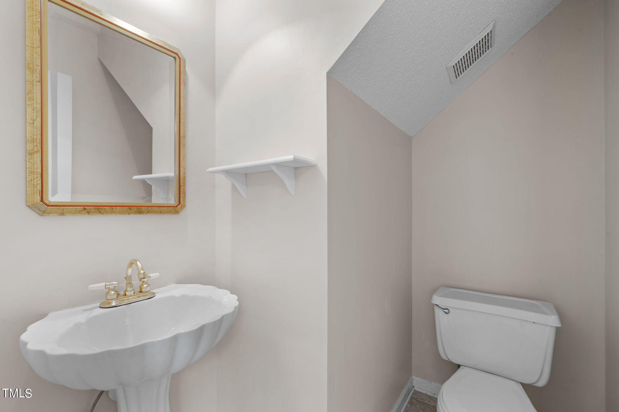 4624 Timberhurst Drive Raleigh, NC 27612 - Photo 14 of 29 a bathroom with a toilet sink and mirror