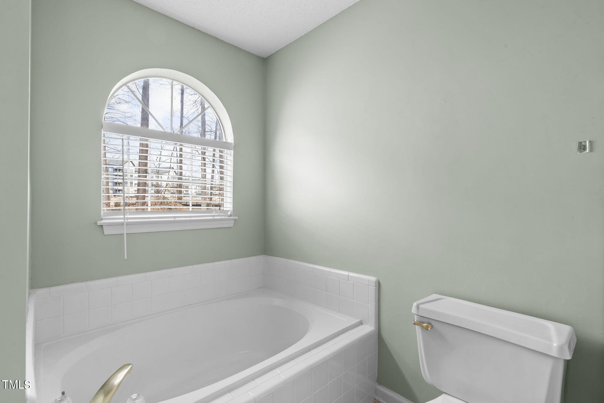 4624 Timberhurst Drive Raleigh, NC 27612 - Photo 23 of 29 a white bath tub sitting next to a toilet