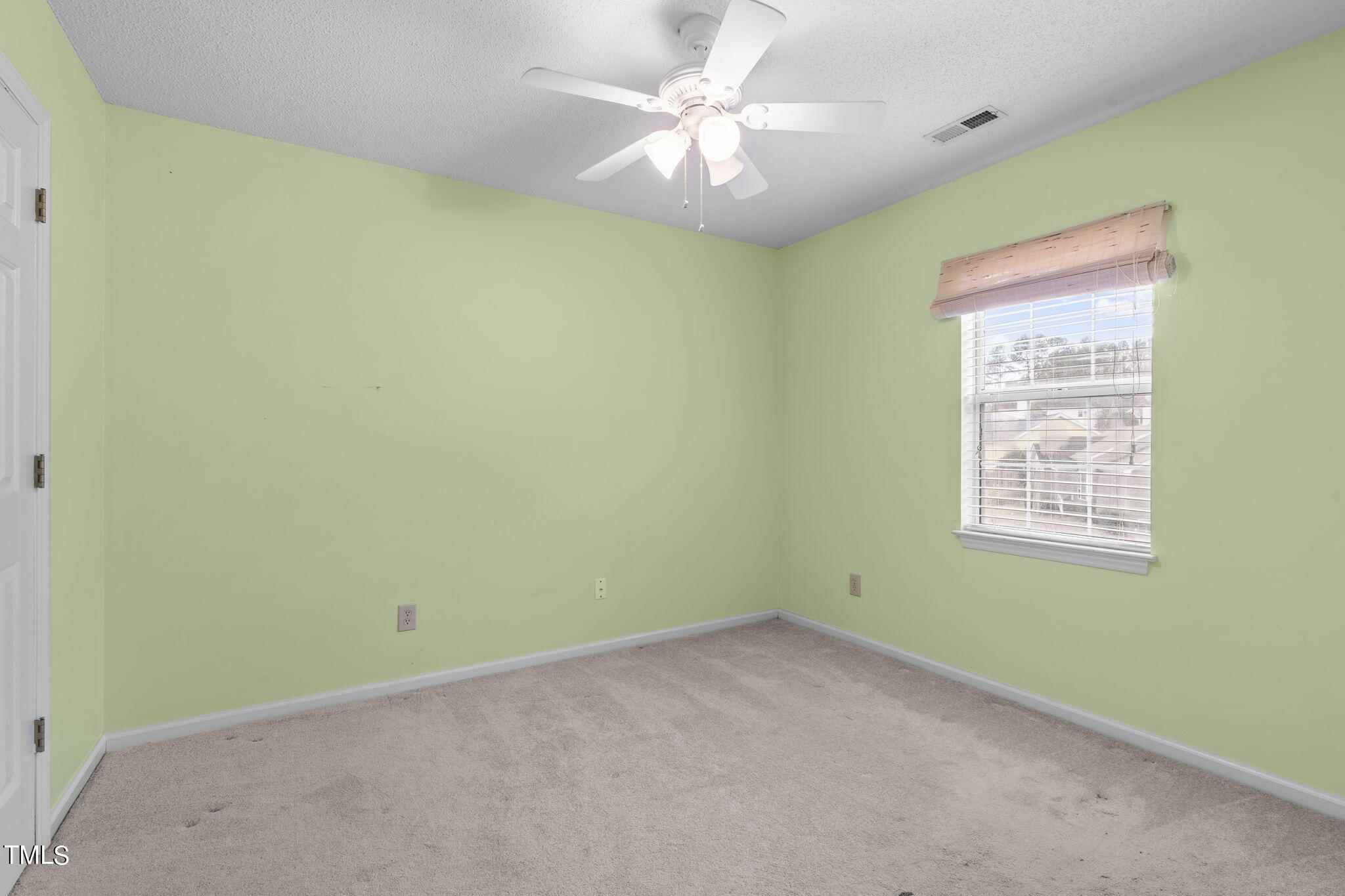 4624 Timberhurst Drive Raleigh, NC 27612 - Photo 24 of 29 an empty room with a window and a fan