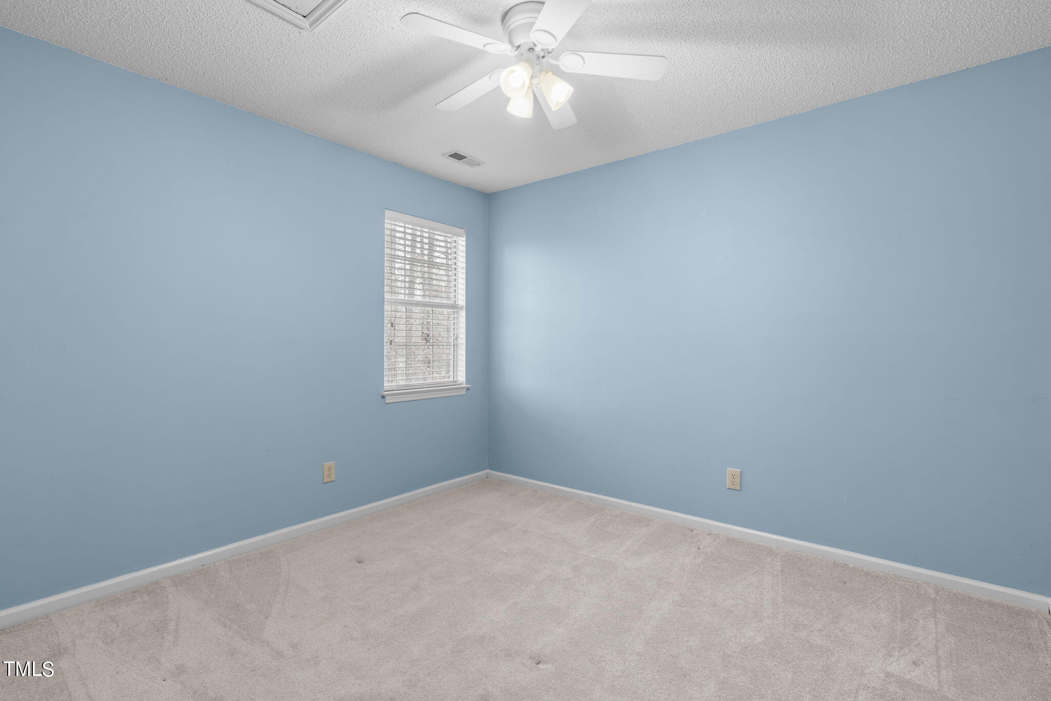 4624 Timberhurst Drive Raleigh, NC 27612 - Photo 27 of 29 an empty room with a window and a fan