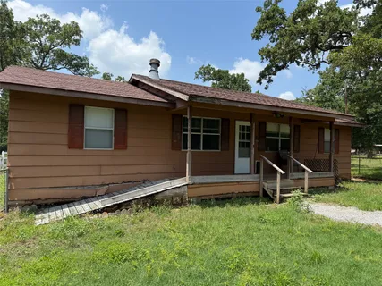 a view of a house with a yard and sitting area
