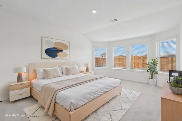 a spacious bedroom with a bed and a large window