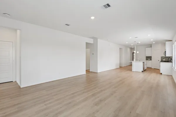 a view of kitchen with a refrigerator wooden floor and a window