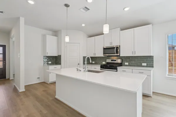 a kitchen with kitchen island a sink stainless steel appliances and cabinets
