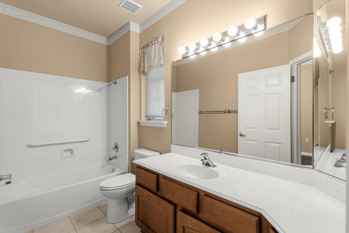 211 Whispering Wind Drive Georgetown, TX 78633 - Photo 11 of 33 Full bath with vanity, washtub / shower combination, crown molding, and light tile patterned flooring
