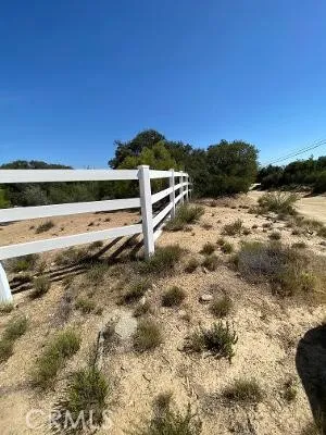 a view of a yard with wooden fence