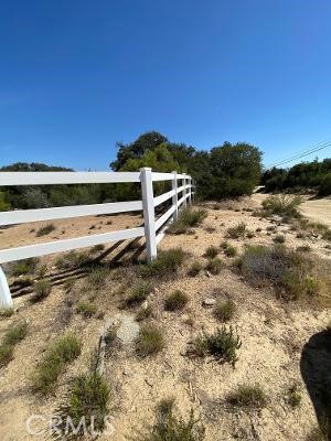 a view of a yard with wooden fence