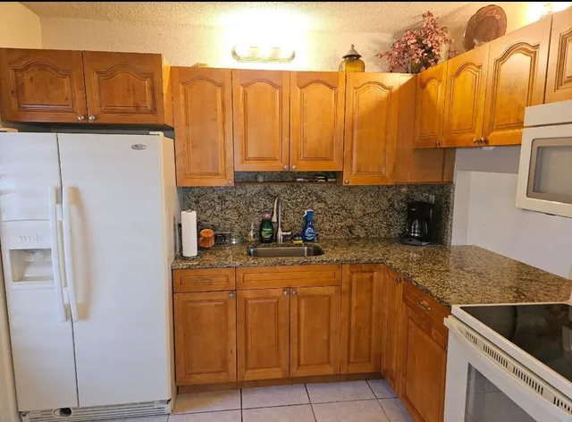 a kitchen with stainless steel appliances granite countertop a refrigerator and a stove