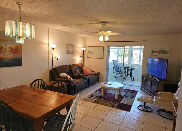 a living room with furniture a chandelier and a dining table