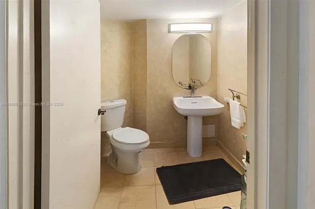 a bathroom with a sink toilet and a mirror