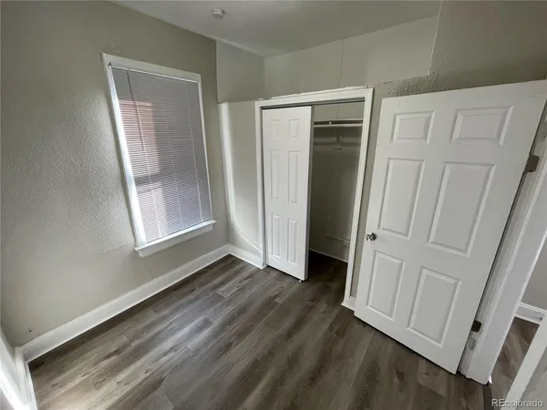 an empty room with wooden floor and a window
