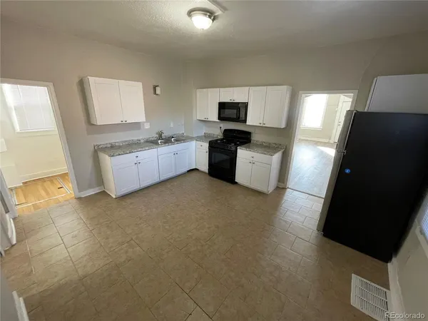 a large white kitchen with a stove a sink dishwasher and a refrigerator