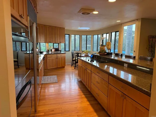 a large kitchen with stainless steel appliances a large counter top a stove and a refrigerator