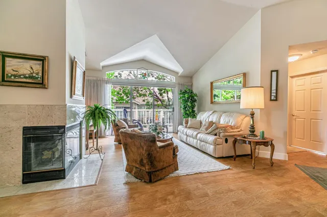 a living room with furniture a fireplace and a large window